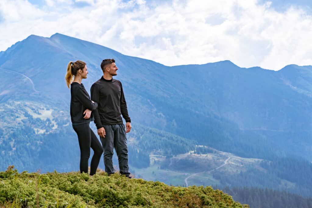 Discover 10+ comfortable ideas what to wear on a hiking date couple standing on summit 1024x683 1