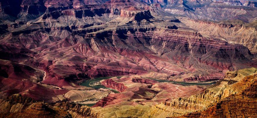 Bryce Canyon vs Grand Canyon: Key Differences to Help You Choose Panoramic view of the Grand Canyon with layered rock formations and Colorado River