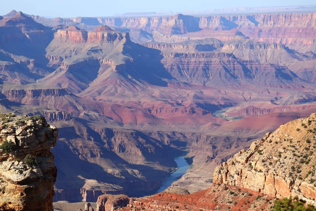 Scenic view of the Grand Canyon with layered rock formations and Colorado River.
